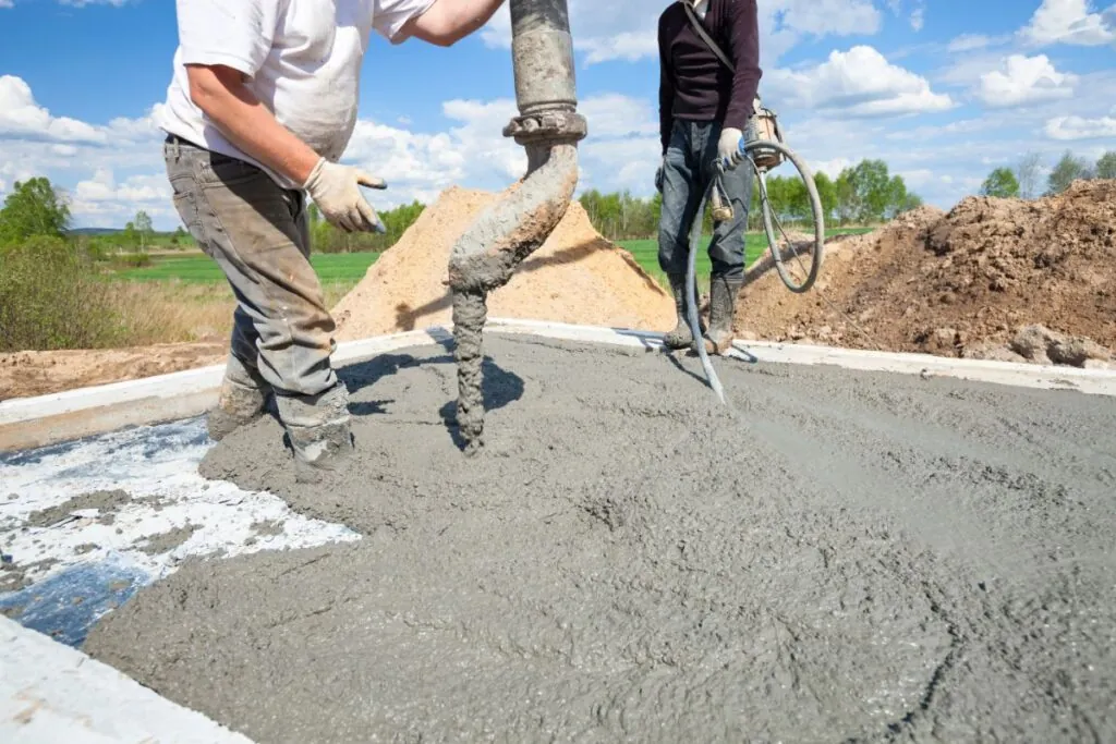 a two contractors pouring concrete slab